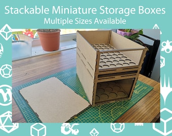 May include: Two stackable light brown storage boxes made of wood composite material with clear front panels and circular cutouts on the top surfaces. The text Stackable Miniature Storage Boxes Multiple Sizes Available is visible at the top.