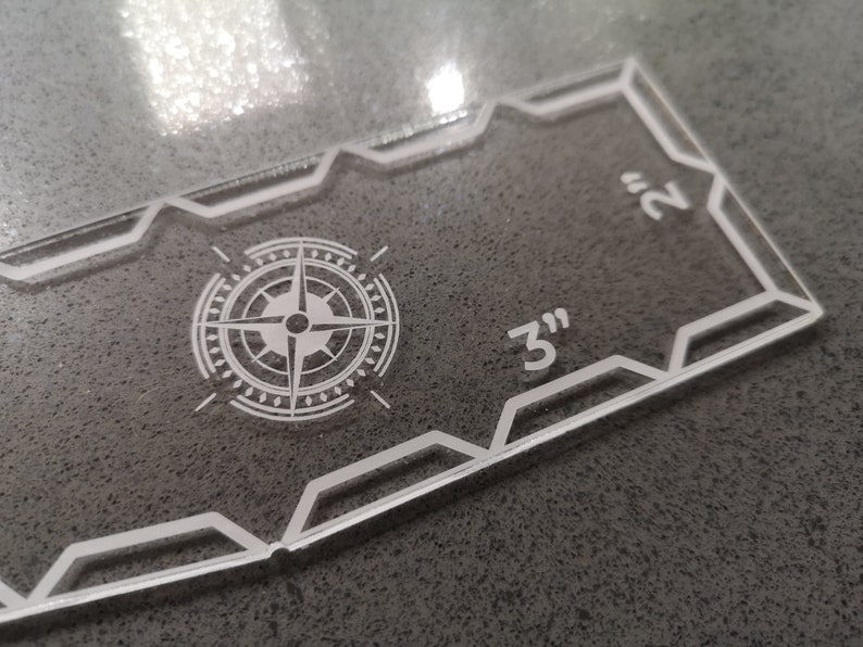 May include: Clear acrylic quilting template with a compass rose design and measurements. The template is 3 inches by 2 inches.