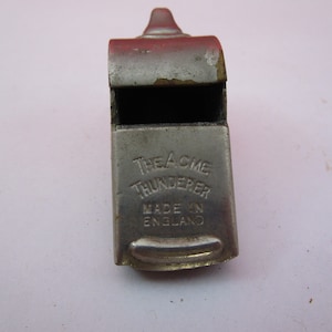 May include: A silver whistle with the words "The Acme Thunderer" and "Made in England" engraved on the side.