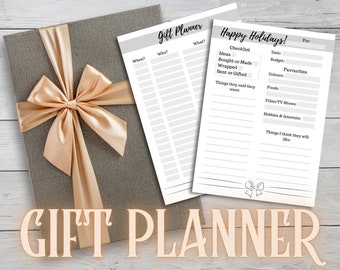 May include: A gray gift box with a gold satin bow, next to two white paper gift planners. The gift planners have text that reads "Gift Planner" and "Happy Holidays!" with sections for notes and checklists. The words "Gift Planner" are also displayed in a decorative font.