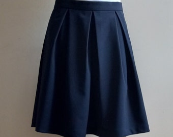 May include: A dark blue pleated skirt with a straight hemline.