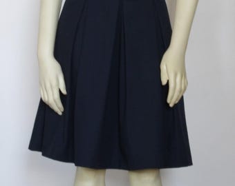 May include: A dark blue pleated skirt with a straight hemline.