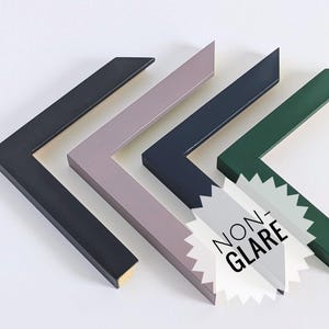 Peut inclure: Quatre échantillons de coins de cadre photo en forme de L, de couleurs noir, mauve clair, bleu foncé et vert forêt. Un autocollant blanc en forme d'étoile avec le texte NON-GLARE est placé sur les coins bleu foncé et vert.