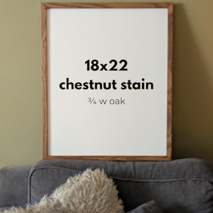 May include: A rectangular wooden picture frame with a chestnut stain and a 3/4 inch wide oak profile. The center of the frame contains white text that reads 18x22, chestnut stain, and 3/4 w oak, indicating the dimensions and material finish.