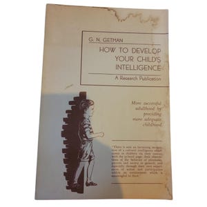 May include: Vintage book cover titled "HOW TO DEVELOP YOUR CHILD'S INTELLIGENCE" by G.N. Getman. The cover features a sepia-toned illustration of a young boy and text. The book is a research publication, with text about childhood development.