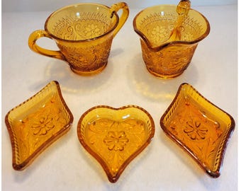 Juego vintage de 5 piezas de vidrio prensado color ámbar: lechera, azucarero y platos con diseño de corazón y diamante.