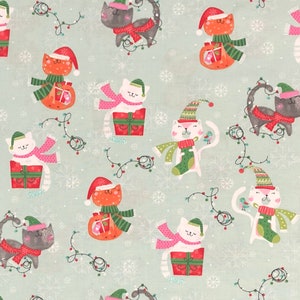 May include: A green background with a repeating pattern of white cats wearing Christmas hats and scarves. The cats are holding presents and some are wearing jingle bells. There are also red and green lights and snowflakes.