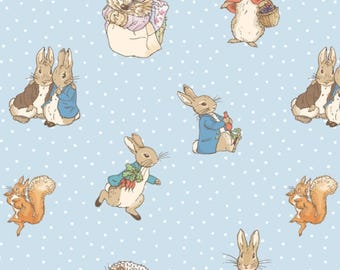 May include: A repeating pattern on a light blue background with white polka dots. The pattern features illustrations of rabbits, squirrels, and a hedgehog, all dressed in clothing. The rabbits are carrying baskets and carrots.