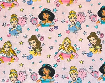 May include: Pink fabric with cartoon illustrations of princesses, stars, hearts, clocks, and other decorative elements. The princesses are shown in different poses and outfits, forming a repeating pattern across the fabric.