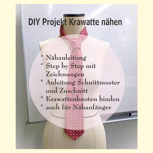 Könnte beinhalten: Eine rosa gemusterte Krawatte wird auf einer Schaufensterpuppe präsentiert. Die Krawatte ist Teil eines DIY-Projekts mit deutschem Text, der Anweisungen zum Nähen einer Krawatte enthält, einschließlich Schritt-für-Schritt-Anleitungen.