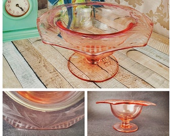 May include: A vintage pink glass candy dish with a scalloped edge and a pedestal base. The dish has a delicate etched design.