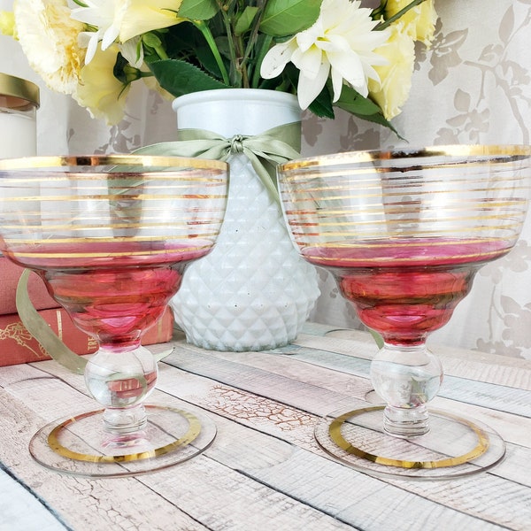 Lovely pair of cranberry glass champagne toasting goblets decorated gold stripes, midcentury barcart, boho wedding