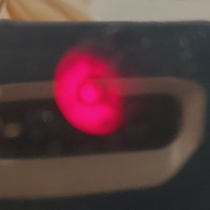 K&ouml;nnte beinhalten: Nahaufnahme eines roten Lichts auf einem schwarzen Ger&auml;t.