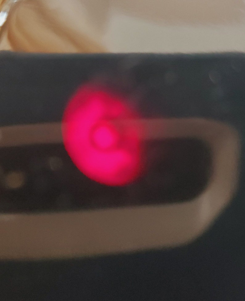 K&ouml;nnte beinhalten: Nahaufnahme eines roten Lichts auf einem schwarzen Ger&auml;t.