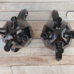 K&ouml;nnte beinhalten: Ein schwarzes Glas-Zucker- und Sahne-Set mit einem einzigartigen, geometrischen Design. Das Set ist aus schwarzem Glas gefertigt und hat eine gl&auml;nzende Oberfl&auml;che. Die Sahnegie&szlig;kanne und die Zuckerdose haben jeweils drei Beine.