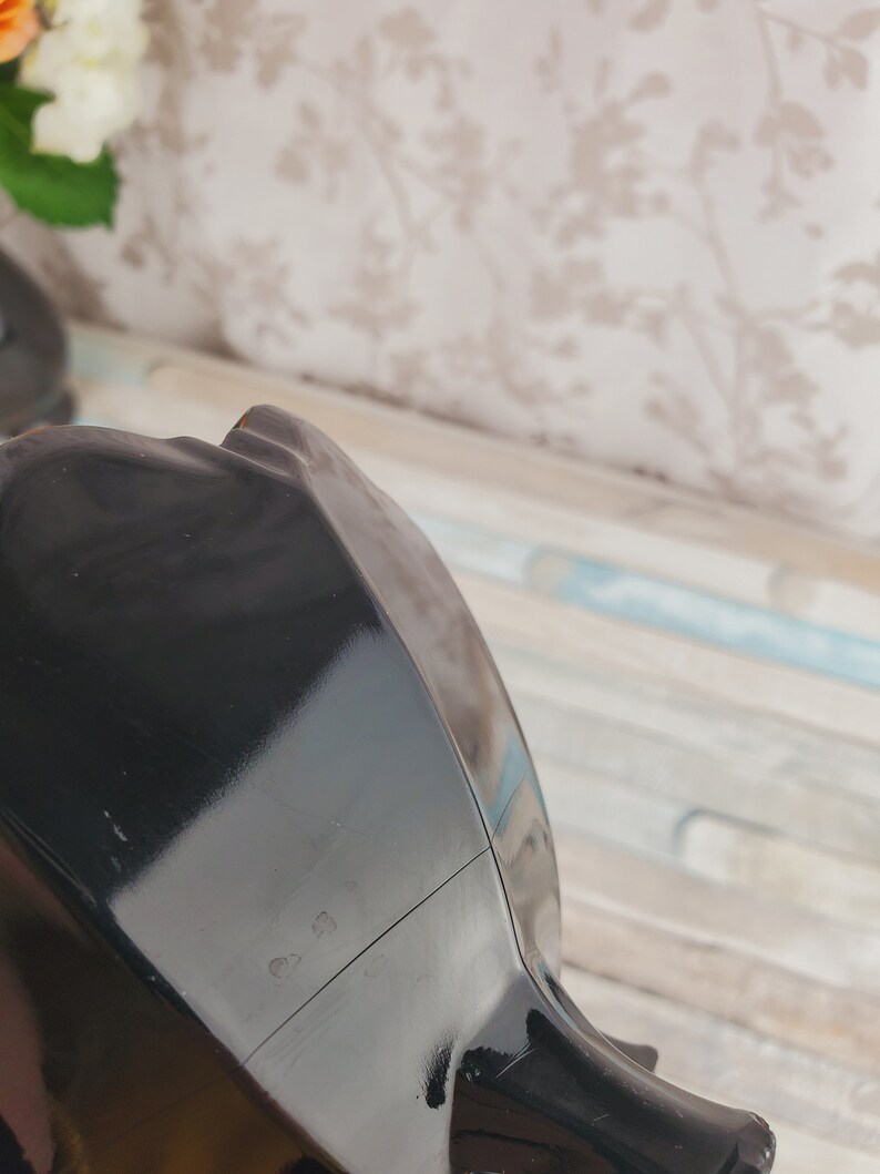 K&ouml;nnte beinhalten: Schwarze Teekanne aus Keramik mit gl&auml;nzendem &Uuml;berzug. Die Teekanne hat einen runden Korpus und einen Ausguss auf einer Seite. Auf der Unterseite der Teekanne befindet sich eine kleine Markierung mit der Aufschrift "633".