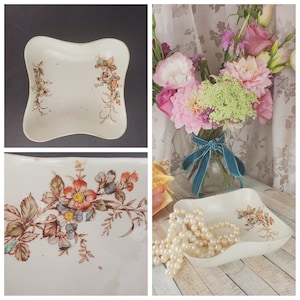 May include: A white porcelain dish with a scalloped edge and floral design. The dish has a floral pattern in shades of pink, red, and blue. The dish is sitting on a wooden surface.