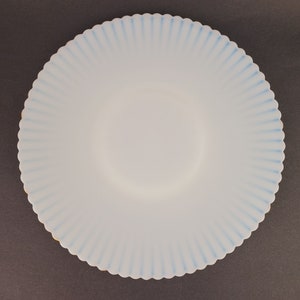 K&ouml;nnte beinhalten: Ein wei&szlig;er Teller mit gewelltem Rand und einem blau-wei&szlig;en Streifenmuster. Der Teller ist aus Glas und hat eine matte Oberfl&auml;che.
