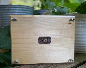 May include: The back of a wooden sign with a metal plate that says "Grateful". The sign has four silver metal brackets attached to the corners.