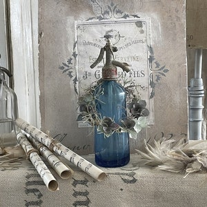 Old blue soda bottle with wreath***