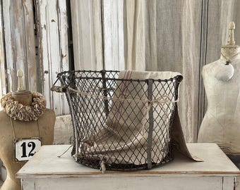 Antigua cesta de hierro con asa de madera: una encantadora pieza del pasado.