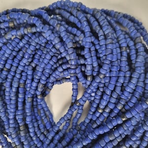 Könnte beinhalten: Nahaufnahme einer großen Spule mit blauen Glasperlen. Die Perlen sind klein und rund und in einer engen Spirale angeordnet.