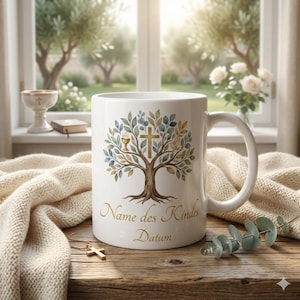 Könnte beinhalten: Weiße Keramiktasse mit einem Baumdesign, einem Kreuz und einem Kelch. Auf der Tasse steht in goldener Schrift "Name des Kindes Datum". Die Tasse steht auf einer Holzoberfläche mit einer goldenen Kreuzkette.