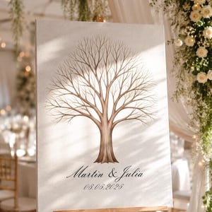May include: A rectangular canvas print on a wooden easel featuring a brown illustration of a leafless tree with many branches. Below the tree, the text reads "Martin & Julia" in a script font, followed by the date "06.06.2026" in a serif font.