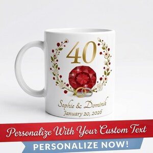 Può includere: Una tazza in ceramica bianca con il numero 40 in oro, una grande gemma rossa sfaccettata e una ghirlanda di fiori bianchi e bacche rosse. Sotto il disegno si trovano due anelli intrecciati, i nomi Sophie & Dominik e la data 20 gennaio 2026.