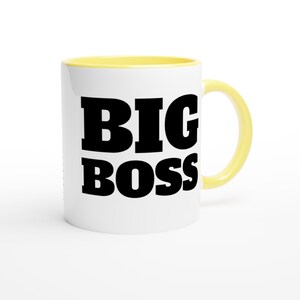 May include: White ceramic mug with a yellow interior and handle. The mug features the words "BIG BOSS" in bold, black letters, centered on the front.