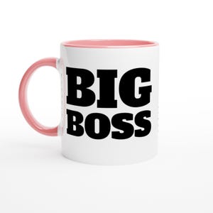 May include: White ceramic mug with a pink interior and handle. The mug features the words "BIG BOSS" in bold, black capital letters. The mug is designed for hot or cold beverages.