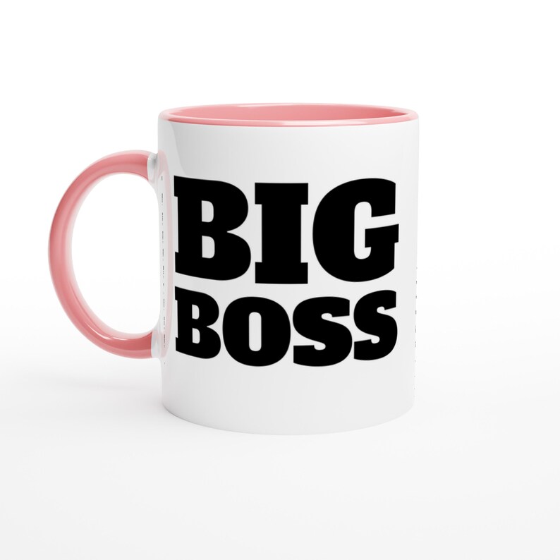 May include: White ceramic mug with a pink interior and handle. The mug features the words "BIG BOSS" in bold, black capital letters. The mug is designed for hot or cold beverages.