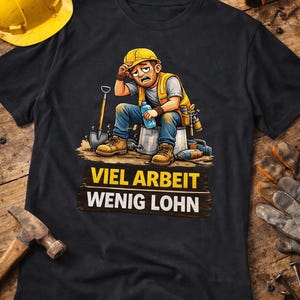 Peut inclure: T-shirt noir avec un dessin animé d'un ouvrier du bâtiment stressé. Le texte sur le t-shirt se lit "VIEL ARBEIT WENIG LOHN". Un casque jaune, un marteau et une perceuse sont visibles. Fond en bois.