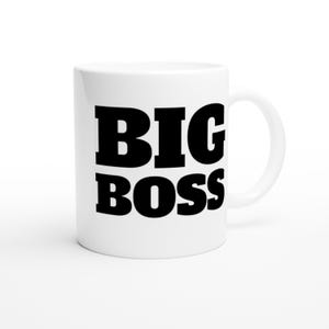 May include: White ceramic mug with the words "BIG BOSS" printed in bold black letters. The mug has a standard handle and a glossy finish. The mug is designed for hot or cold beverages.