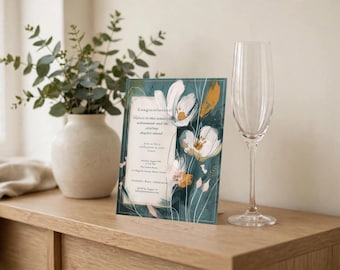 Op de afbeelding: Een rechthoekige uitnodigingskaart met een donkergroenblauwe achtergrond en abstracte witte en gouden bloemillustraties. De tekst luidt Congratulations, Here's to this wonderful achievement and the exciting chapter ahead, Join us for a celebration in your honor.