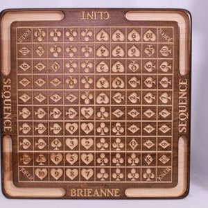 Pu&ograve; includere: Un tabellone da gioco in legno con una griglia di carte, numerate da 2 a 10, Jack, Queen, King e Ace. I semi sono cuori, diamanti, fiori e picche. Il tabellone &egrave; personalizzato con i nomi "Clint" e "Brianne".