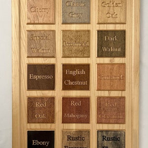 Pu&ograve; includere: Un pannello di legno con 15 diversi campioni di tinta per legno. I campioni sono etichettati con i nomi delle tinte, come "Ciliegio", "Grigio Classico", "Rovere Dorato", "Noce Speciale", "Provinciale", "Noce Scuro", "Espresso", "Castagno Inglese", "Gunstock", "Rovere Rosso", "Mogano Rosso", "Castagno Rosso", "Ebano", "Espresso Rustico" e "Ebano Rustico".