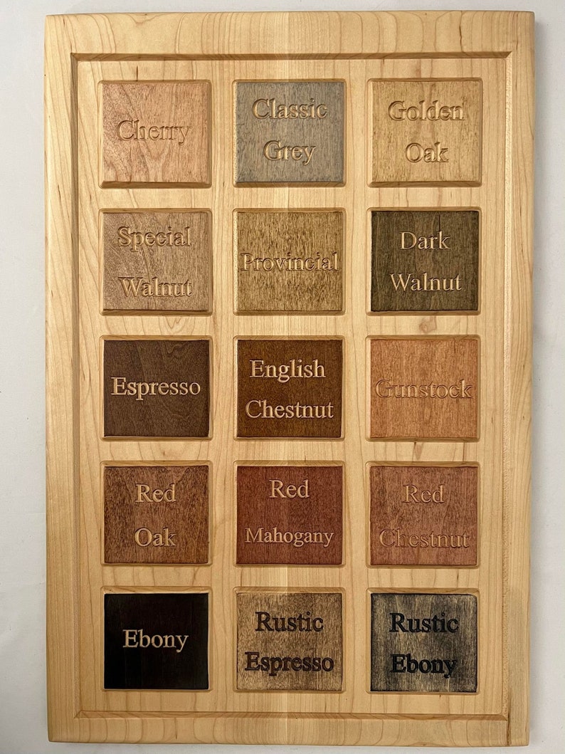 Pu&ograve; includere: Un pannello di legno con 15 diversi campioni di tinta per legno. I campioni sono etichettati con i nomi delle tinte, come "Ciliegio", "Grigio Classico", "Rovere Dorato", "Noce Speciale", "Provinciale", "Noce Scuro", "Espresso", "Castagno Inglese", "Gunstock", "Rovere Rosso", "Mogano Rosso", "Castagno Rosso", "Ebano", "Espresso Rustico" e "Ebano Rustico".