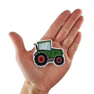 Peut inclure: Patch brodé représentant un tracteur vert et noir avec des roues rouges. Le patch est thermocollant et peut être utilisé pour décorer des vêtements, des sacs ou d'autres articles.
