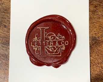 Seal stamp engraved with name and large background letter initial