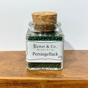 Parelmoer zegellak donkergroene zegellak in parelvorm in een glas met kurk
