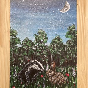 May include: A rectangular painting on canvas featuring a black and white badger and a brown rabbit standing in a green meadow filled with small red and purple flowers. The background shows a dark forest under a starry night sky with a crescent moon.