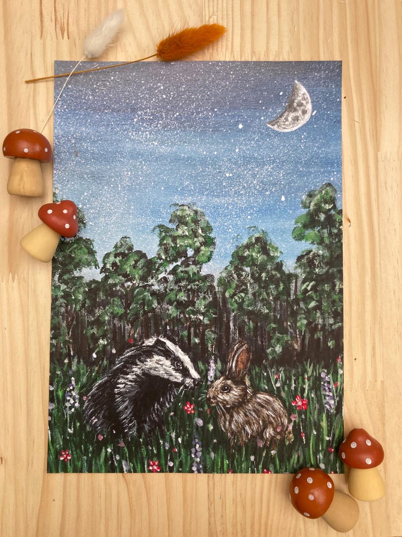 May include: A rectangular art print featuring a painted scene of a badger and a rabbit in a grassy meadow at night. The background shows a dark blue starry sky with a crescent moon above a dense forest of green trees and colorful wildflowers.