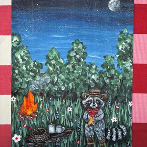 May include: A painting of a raccoon wearing a brown hat, red bandana, and boots, standing in a grassy field with white flowers. A bright orange campfire burns near a log with two mugs, under a dark blue night sky with a full moon and stars.