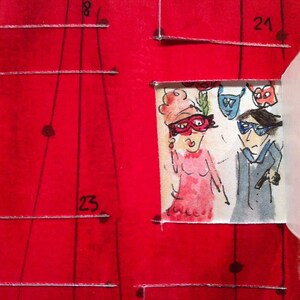 May include: A red calendar with handwritten numbers 8, 21, and 23. A small white paper with a drawing of two people wearing masks and costumes is attached to the calendar.
