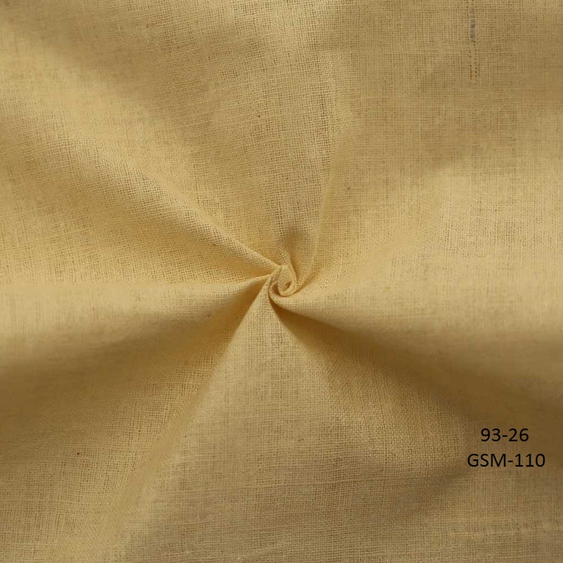 May include: A close-up of a pale yellow fabric with a textured weave. The fabric is folded and twisted, showing its drape and texture. The text "93-26 GSM-110" is printed in the bottom right corner.