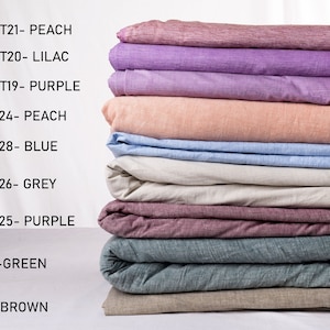 May include: A stack of ten fabric swatches in various colors, including peach, lilac, purple, blue, grey, green, and brown. The swatches are labeled with their corresponding colors and codes, such as MT21-PEACH, MT20-LILAC, and N24-PEACH.