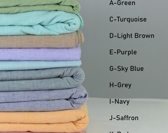 Può includere: Un mucchio di dieci campioni di tessuto in diversi colori, tra cui verde, turchese, marrone chiaro, viola, azzurro cielo, grigio, blu navy, zafferano e rosso. Ogni campione è piegato a metà e impilato uno sopra l'altro.