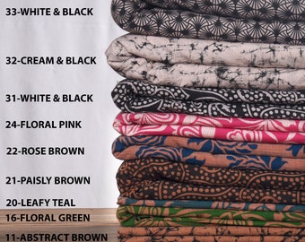 May include: A stack of ten fabric squares in various colors and patterns, including white, black, cream, pink, brown, teal, and green. The fabric squares are labeled with numbers and color descriptions.
