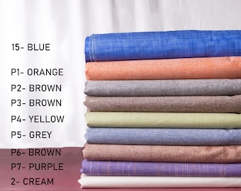 Könnte beinhalten: Ein Stapel Stoffmuster in verschiedenen Farben, darunter Blau, Orange, Braun, Gelb, Grau, Lila und Creme. Die Muster sind mit Nummern und Farbnamen beschriftet.